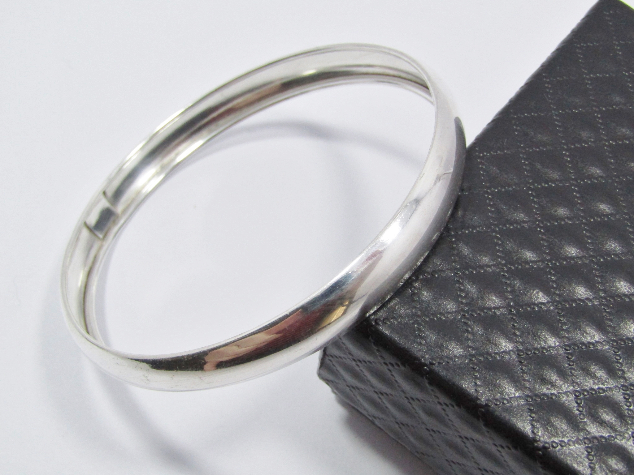 A Lovely Broad D Shape Bangle in Sterling Silver.