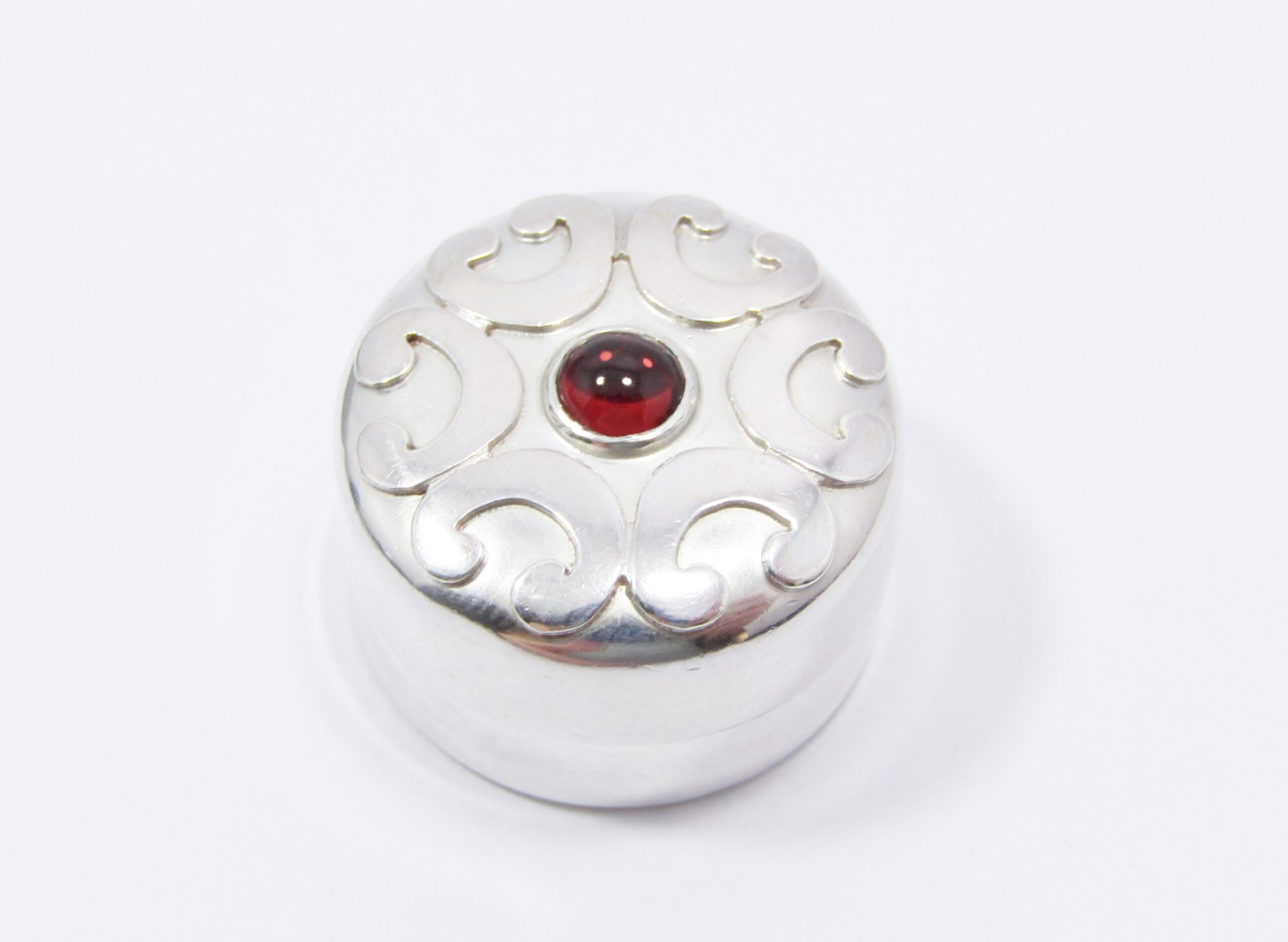 A Lovely Round Pill Box With a Garnet Stone in Sterling Silver.