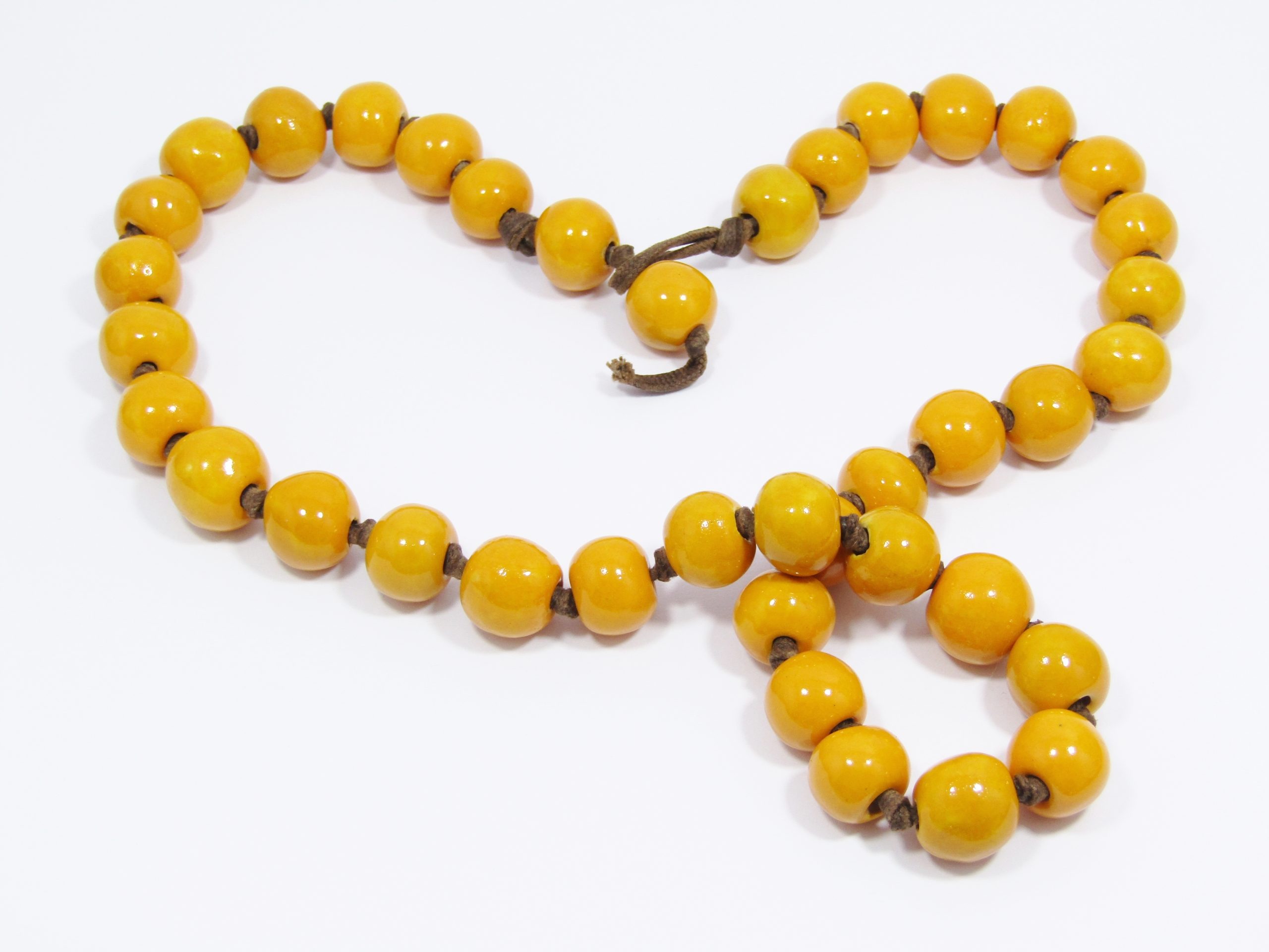 A Gorgeous String of Striking Yellow Glazed Pottery Beads on a leather Cord