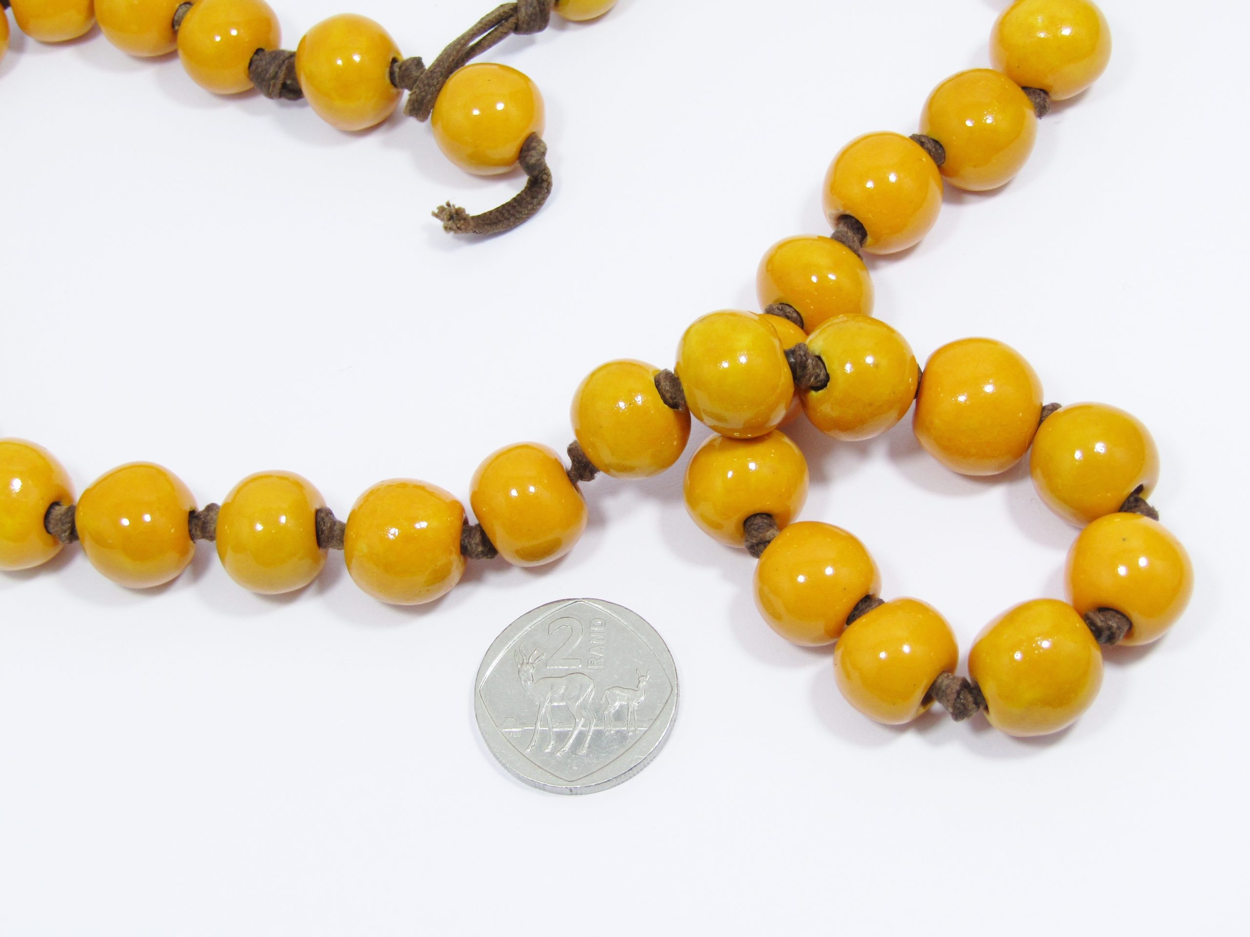 A Gorgeous String of Striking Yellow Glazed Pottery Beads on a leather Cord