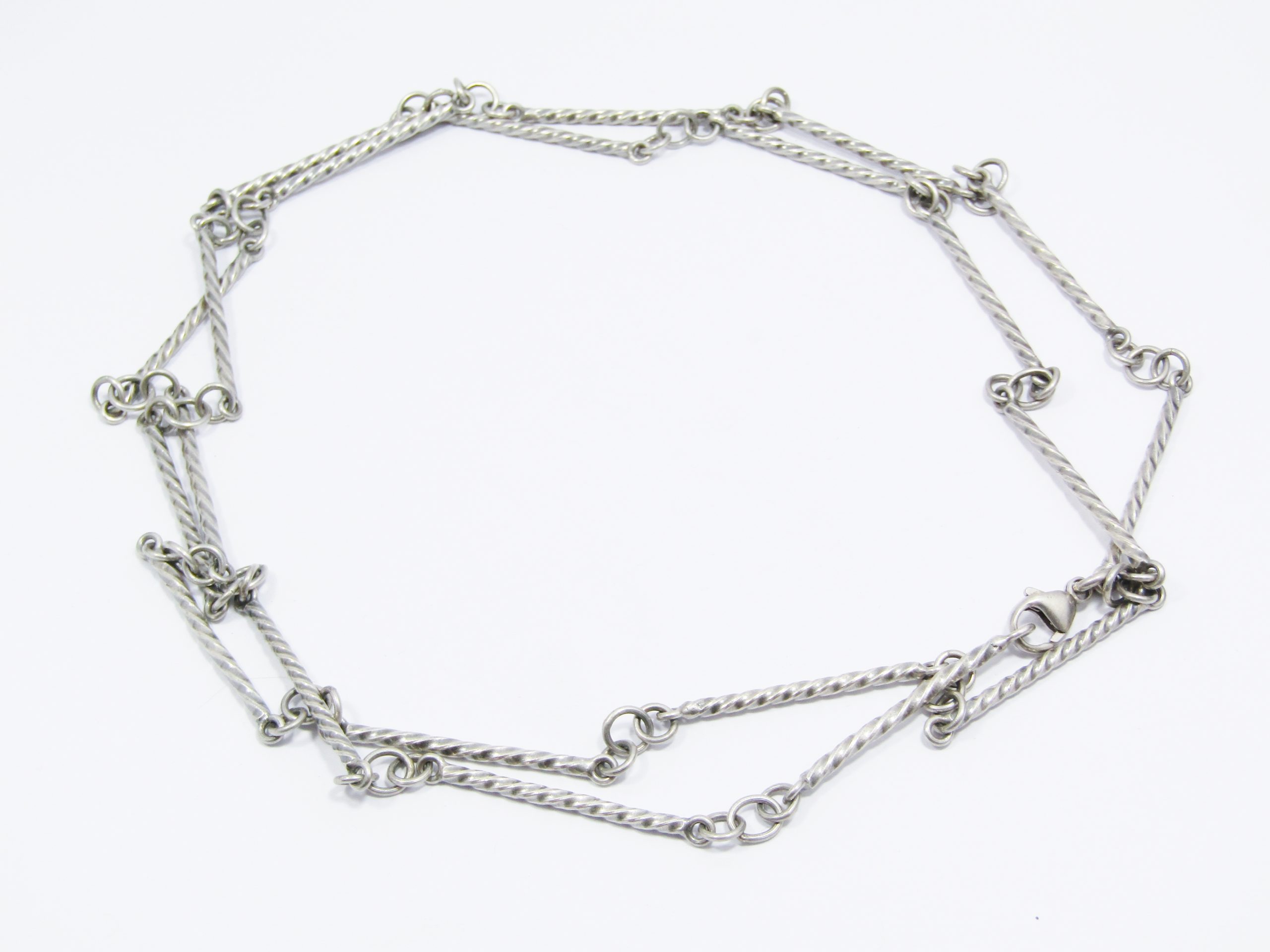 A Gorgeous Weighty Long Twisted Paneled Necklace in Sterling Silver.
