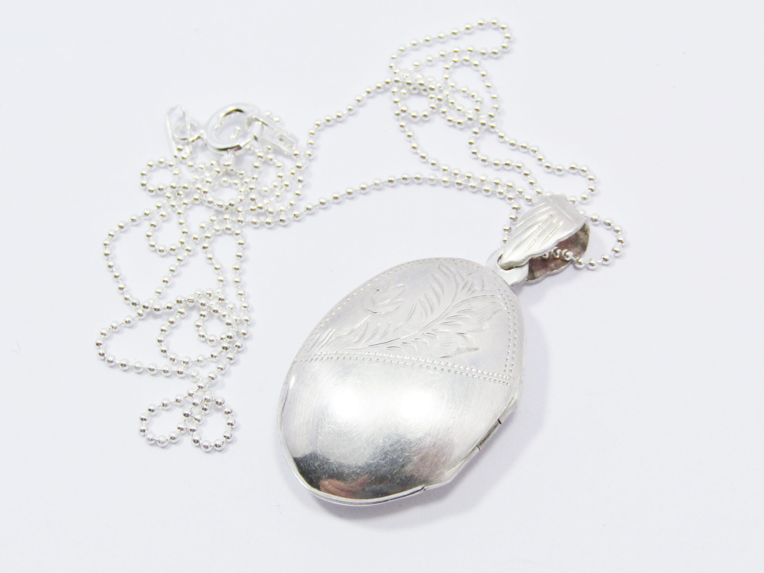 A Lovely Oval Vintage Design Engraved Locket on Chain in Sterling Silver.