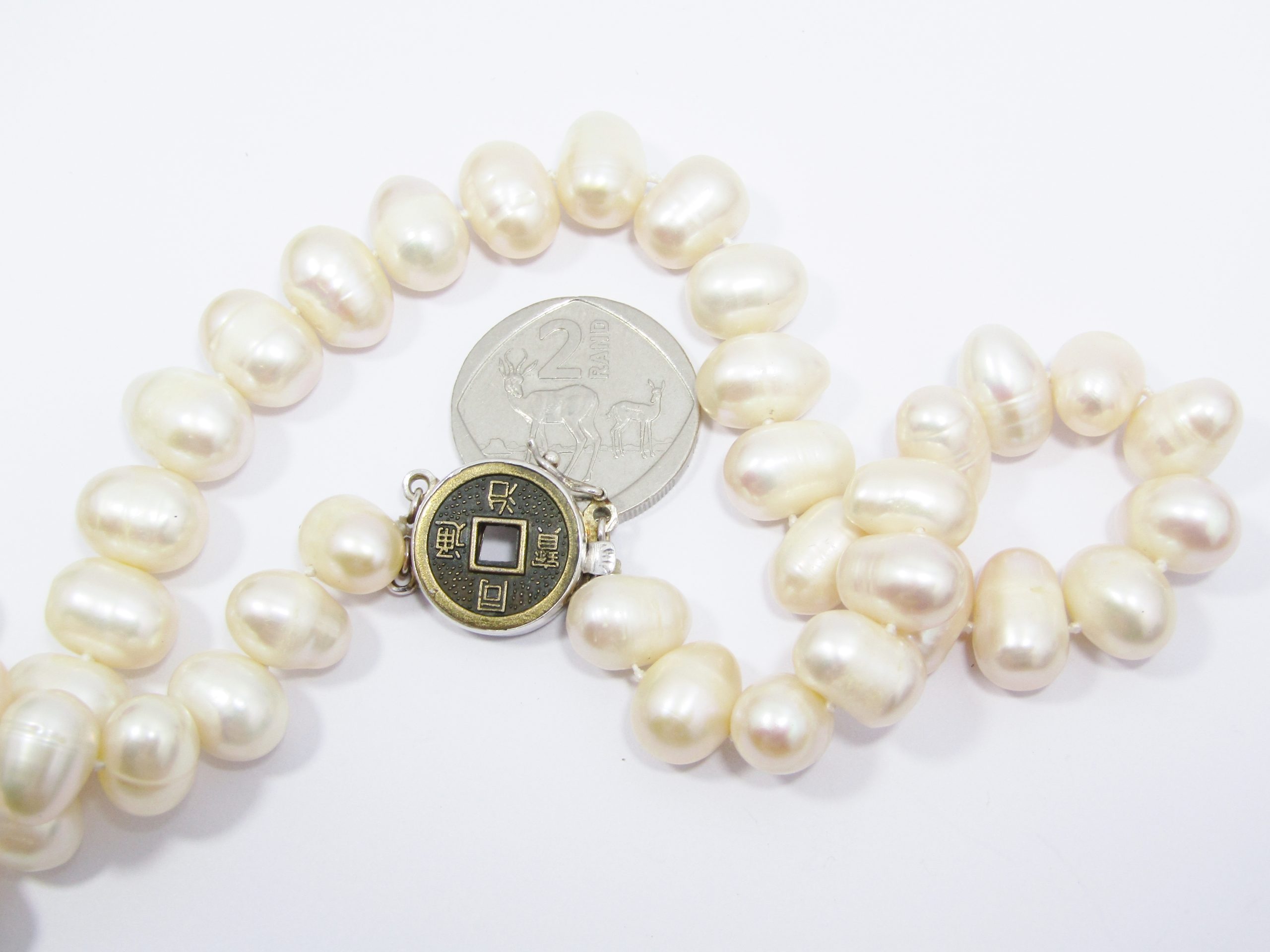 A Gorgeous String of Fresh Water Pearls with a good luck Coin Clasp in Sterling Silver